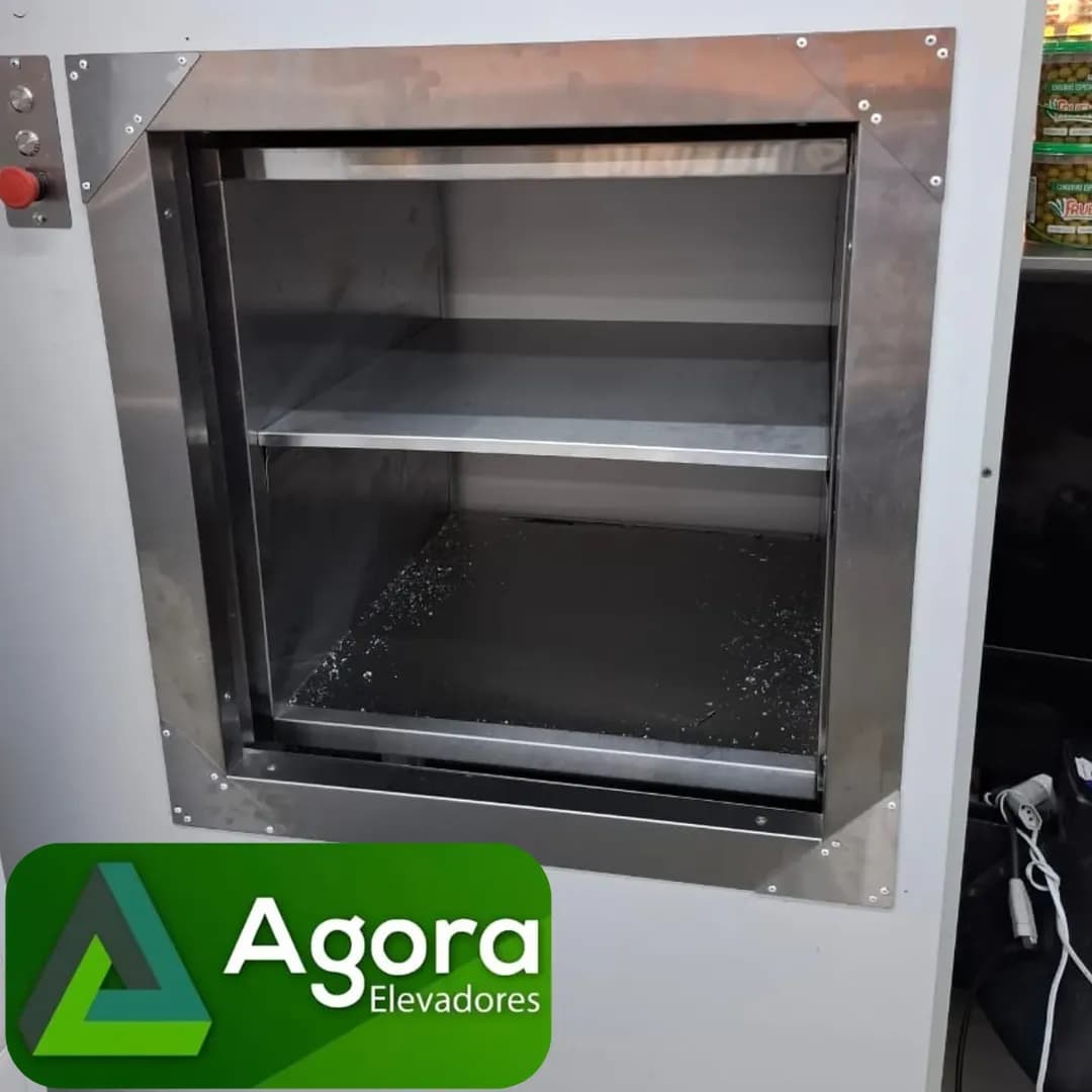 Monta carga em aço inoxidável instalado na parede com identidade visual da empresa