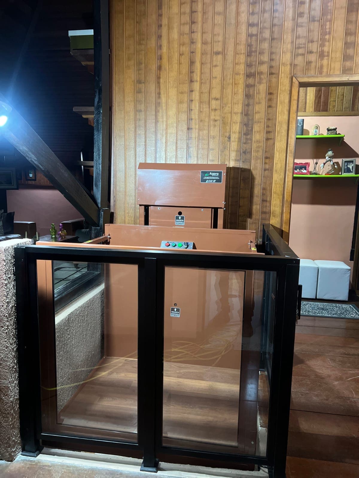 Plataforma residencial simples em meia cabine instalada em casa com revestimento de madeira